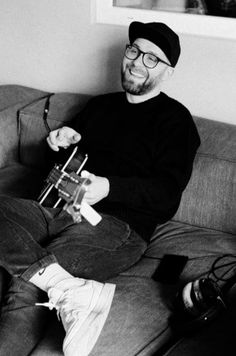 a black and white photo of a man sitting on a couch