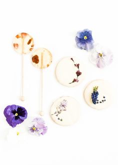 four edible flowers are arranged on top of each other, including one purple pansy