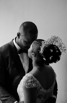 a bride and groom embracing each other in black and white