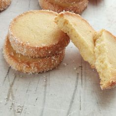 some sugar covered cookies sitting on top of a white countertop next to each other