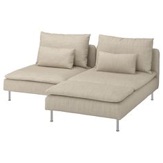 a white couch with pillows on it sitting next to a pillow case and metal legs