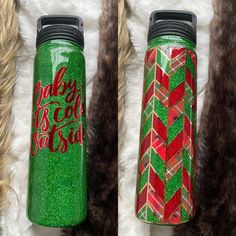 two green and red water bottles sitting next to each other on top of a fur rug