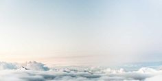 an airplane is flying high above the clouds