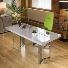 a laptop computer sitting on top of a white table next to a green chair and potted plant