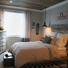 a bedroom with a bed, dressers and window in it's center area