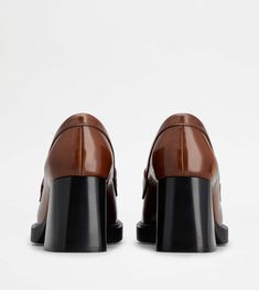 Characterized by a leather block heel and outsole with embossed rubber pebbles, these loafers come with the elegant metal T Chain accessory. Crafted in brushed calfskin leather, they are a extremely versatile contemporary style. Brown Loafers, Leather Block Heels, Heeled Loafers, Leather Heels, Contemporary Style, Calf Skin, Block Heels, Leather Upper, Dust Bag