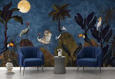 two blue chairs sitting in front of a wall with birds on it and palm trees