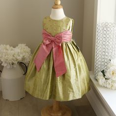 This 100% Raw Dupioni Silk Dress In Size 2t Is Gorgeous! The Chartreuse Green Is Lovely! The Deep Coral Pink Accents Make This Dress Fit For A Little Princess. A Wide Coral Pink Sash And Bow Adorn The Front Of The Dress. Matching Embroidered Circles Embellish The Bodice. The Rounded Neckline Is Trimmed In A Matching Piping. The Back Has A Three Button Closure Done In Matching Green Pearlized Buttons With The "Luli" Trademark Inscribed. A Matching Green Silk Fabric Belt With Two Buttons Adds The Pink Princess Christmas Dress, Holiday Pink Sleeveless Princess Dress, Pink Christmas Dress For Dress-up, Elegant Pink Princess Dress For Festive Occasions, Pink Princess Dress For Dress-up Holiday, Elegant Sleeveless Pink Holiday Dress, Elegant Pink Sleeveless Holiday Dress, Elegant Spring Princess Dress For Festive Occasion, Elegant Sleeveless Princess Dress For Holiday