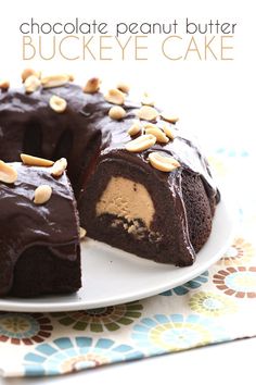 a chocolate peanut butter buckeye cake on a plate with one slice cut out from it