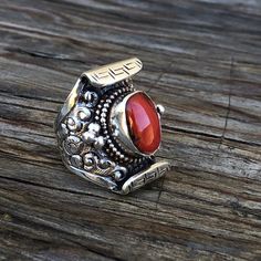 Red coral set on sterling silver traditional Tibetan saddle ringSize ; this ring is adjustable fits sizes 9 to 10 1/2Hight 29mm X W23mmCoral measures approximately ; H 13mm x W 9mm Traditional Oval Red Ring, Handmade Red Toe Ring, Adjustable Red Gemstone Rings, Adjustable Red Oval Ruby Ring, Adjustable Oval Red Ruby Ring, Adjustable Red Oval Ring, Adjustable Oval Red Ring, Unique Red Open Ring Jewelry, Bohemian Red Open Ring Jewelry