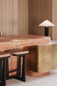 two stools in front of a counter with a lamp on it and another table behind them