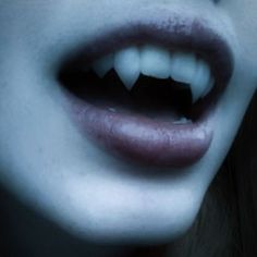 a woman's mouth with white teeth is shown in close up view from the neck down