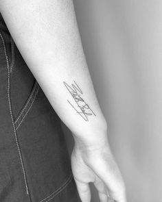 a person's arm with a small tattoo on the left side of their arm