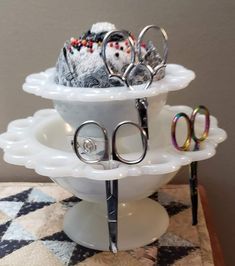 there are many pairs of scissors in the bowl on the table with it's holder