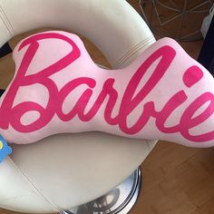 a pink and white dog bone with the word barbie on it's front end