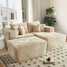 a living room with a large sectional couch and rug on the floor in front of a window