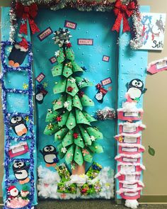 a christmas tree made out of toilet paper and other decorations on a bulletin board in an office cubicle