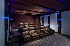 an empty theater with leather seats and blue lights