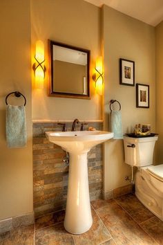 a bathroom with a toilet, sink and mirror in it's center piece is shown