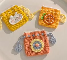 three crocheted purses sitting on top of a white plate