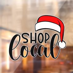 the shop local logo is displayed in front of a store window with a santa hat on it