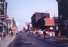 an old photo of people walking down the street