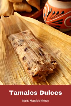 tamales slices on a banana leaf with other food items in the background