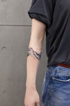 a person with a mountain tattoo on their arm