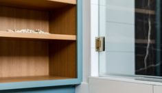 a cabinet with shelves and glass doors in a room that looks like it could be used as a medicine cabinet