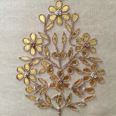 a gold brooch with flowers on it