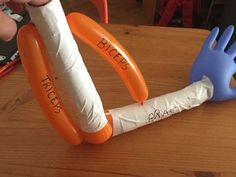 an orange and blue plastic object sitting on top of a wooden table