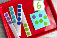 a red tray topped with paper straws and polka dot stick numbers on top of it