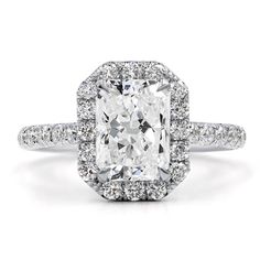 an engagement ring with a cushion cut diamond surrounded by pave diamonds