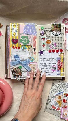 a person's hand is on top of an open book with many stickers