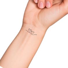 a woman's arm with a small tattoo on the left side of her wrist