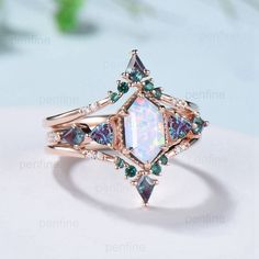 an opal and diamond ring on top of a white surface