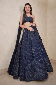 Navy blue dupion silk lehenga with an attached cancan and crystals hand embroidery. Comes with a padded one-shoulder blouse with an attached georgette dupatta. Components: 2 Pattern: Hand embroidered Type Of Work: Crystals Neckline: One Shoulder Sleeve Type: Sleeveless Fabric: Dupion silk, Attached dupatta : Georgette Color: Blue Other Details:  Attached lining Lehenga length : 43 inches Closure : Lehenga - Drawstrings Occasion: Destination Wedding - Aza Fashions One Shoulder Blouse With Attached Dupatta, Strap Blouse Lehenga, Bronze Lehenga, One Shoulder Lehenga, Work Crystals, Navy Blue Lehenga, Aesthetic Bookmarks, Sangeet Outfit, Haldi Outfit