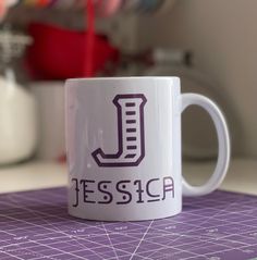 a white coffee mug sitting on top of a purple cutting board