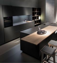 a modern kitchen with black cabinets and counter tops