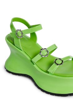 cuz time to be a tourist. These wedge sandals have a patent vegan leather construction, treaded soles, a strappy design, and adjustable daisy buckle closures. Trendy Wedge Sandals With Adjustable Strap For Spring, Trendy Spring Wedge Sandals With Adjustable Strap, Trendy Synthetic Wedge Sandals With Adjustable Strap, Green Sandals With Adjustable Strap, Green Wedge Sandals With Heel And Ankle Strap, Green Summer Wedge Sandals With Ankle Strap, Green Ankle Strap Wedge Sandals For Summer, Spring Wedge Sandals With Adjustable Strap, Green Platform Sandals With Ankle Strap