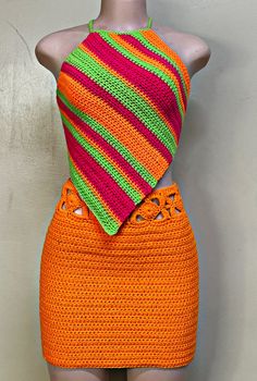 a mannequin wearing an orange and pink crochet dress