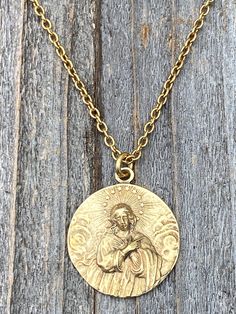 This is a solid gold bronze antique replica of a very rare Assumption of Mary medal from France. I am blessed to own this original and be able to share with you. The photographs do not capture the true beauty of this piece of art. Amazing depth and details! The oxidation and antiquing process highlights the gorgeous details. If you rub your fingers over the medal, Our Lady's face and body are very pronounced. The antique gold 2x3mm cable chain is 20 inches long and the medal is 1 inch round. A l Vintage Brass Medallion Necklace Tarnish Resistant, Gold Brass Spiritual Medallion Necklace, Gold Spiritual Medallion Necklace In Brass, Gold Engraved Brass Medallion Necklace, Gold Engraved Medallion Necklace In Brass, Gold Spiritual Engraved Medallion Necklace, Gold Medallion Necklace With Antique Finish, Spiritual Yellow Gold Medallion Necklace In Brass, Gold Necklace With Round Antique Pendant