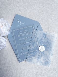 the wedding stationery is laid out on top of each other, with white flowers