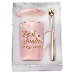 a pink mug with a gold spoon in it and a message on the cup that says, a sister is god's way of making sure