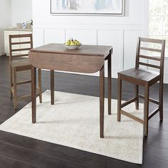 two chairs and a table in a room with hardwood floors, white walls and wood flooring