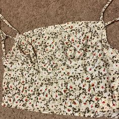 Never Worn. Tan Cropped Top With A White Floral Design. The Back Is Covered By A Strap. Casual Printed Crop Top For Spring, Casual Sleeveless Floral Print Crop Top, Summer Cami Crop Top With Floral Print, Casual Floral Print Crop Top For Beach, Casual Floral Print Crop Top For Day Out, Summer Floral Print Cotton Crop Top, Cotton Floral Print Crop Top For Day Out, Floral Print Cotton Cami Crop Top, Shein Tops