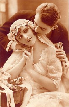 an old photo of two women dressed in wedding attire, one holding the other's head