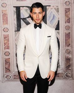 a man in a white suit and bow tie