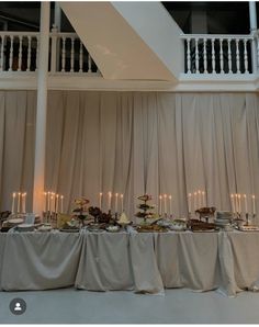 the table is set with many different types of food and candles on top of it