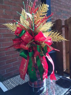 a vase filled with red, green and gold christmas decorations on top of a table